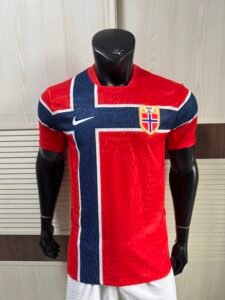 Nike Norway 2026 World Cup Home Jersey front view showing striking Chile red official Norwegian shirt with flag-inspired cross design and Nike Aero-FIT fabric texture